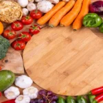 A variety of healthy foods including fruits and vegetables arranged on a wooden surface