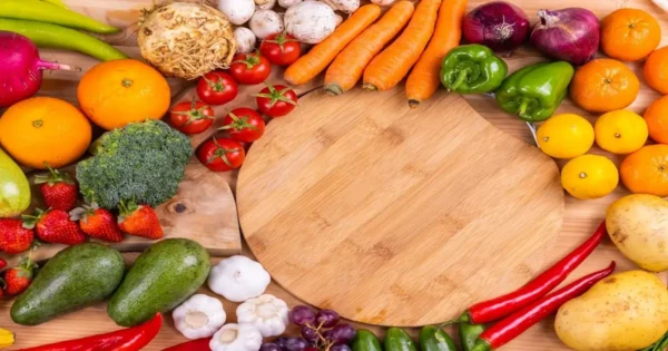 A variety of healthy foods including fruits and vegetables arranged on a wooden surface