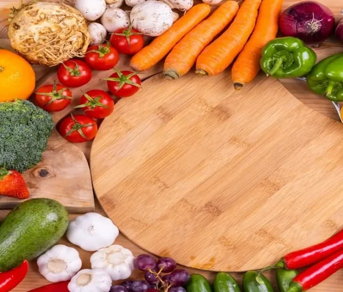 A variety of healthy foods including fruits and vegetables arranged on a wooden surface