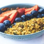 Berries and granola in a bowl showing nutrient-dense and calorie-dense foods together