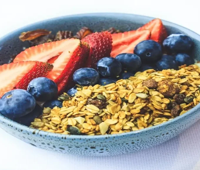 Berries and granola in a bowl showing nutrient-dense and calorie-dense foods together