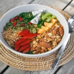 Bowl of fruits, nuts, seeds, and whole grains showing nutrient-dense food variety