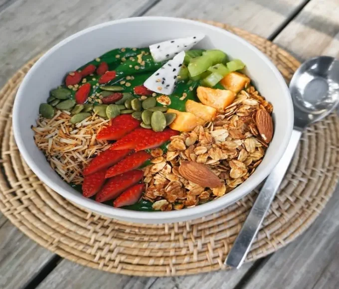 Bowl of fruits, nuts, seeds, and whole grains showing nutrient-dense food variety
