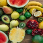 A mix of fruits including banana, berries, citrus, and melon showing variety in daily nutrition