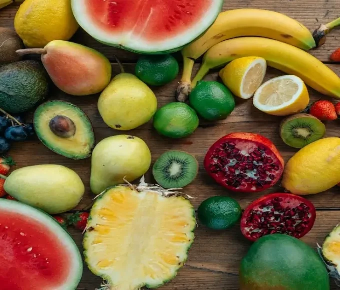 A mix of fruits including banana, berries, citrus, and melon showing variety in daily nutrition
