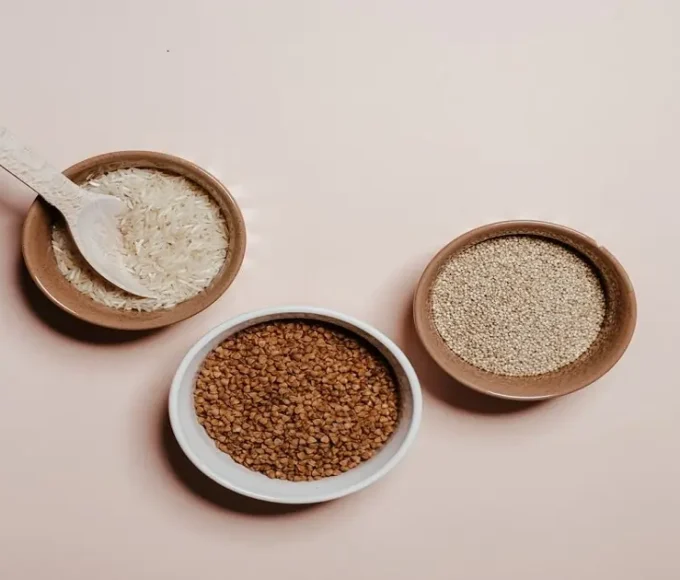 Whole grains in bowls including rice, quinoa, and buckwheat used in daily meals